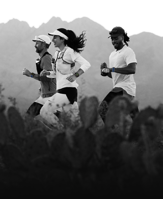 Tres personas corren en un área montañosa usando el Apple Watch Ultra 3